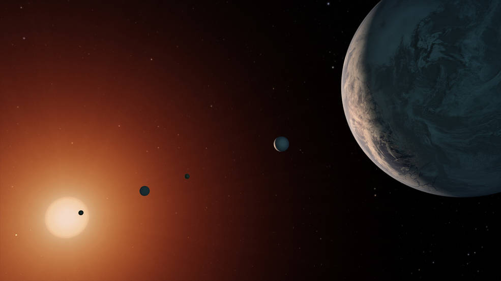 This illustration shows what the TRAPPIST-1 system might look like from a vantage point near planet TRAPPIST-1f (at right)